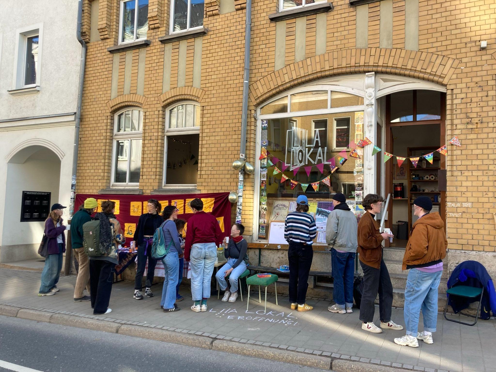 Einige Menschen stehen vor dem Lila Lokal